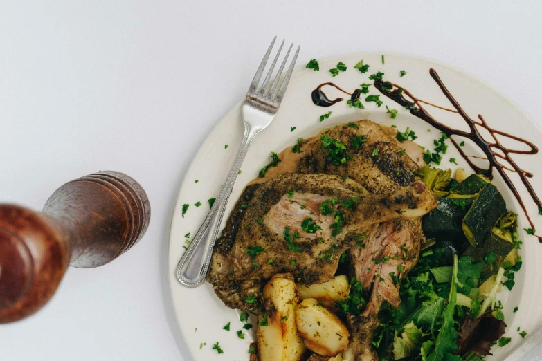 a white plate topped with meat and vegetables, a photo, by Carey Morris, pexels contest winner, renaissance, herbs, half goat, black fork, greens)