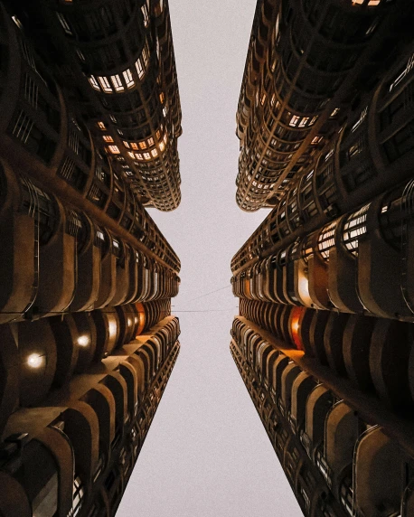 a group of tall buildings sitting next to each other, inspired by Ricardo Bofill, unsplash contest winner, in a massive cavernous iron city, louis sullivan, infinite hallways, bottom view