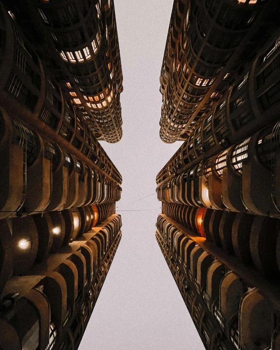 a group of tall buildings sitting next to each other, inspired by Ricardo Bofill, unsplash contest winner, in a massive cavernous iron city, louis sullivan, infinite hallways, bottom view