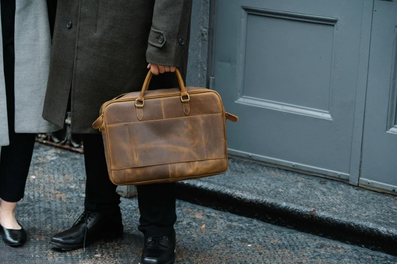 a man and a woman standing next to each other, an album cover, by Emma Andijewska, unsplash, holding a briefcase, caramel. rugged, ready for a meeting, faded worn