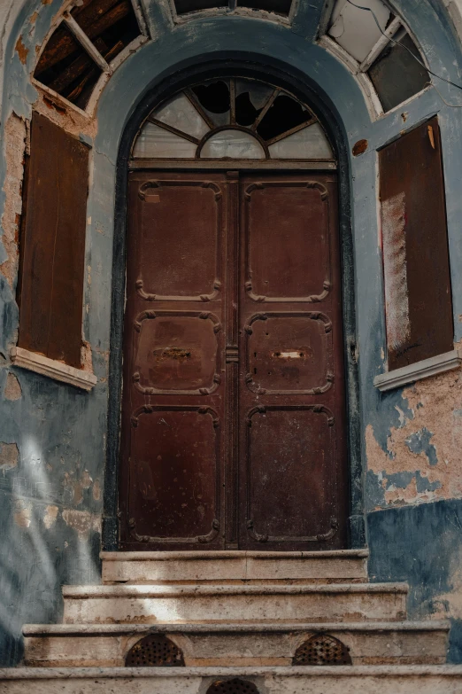 a cat sitting on the steps of an old building, an album cover, by Sven Erixson, pexels contest winner, renaissance, wood door, dull red flaking paint, blue, 3 doors