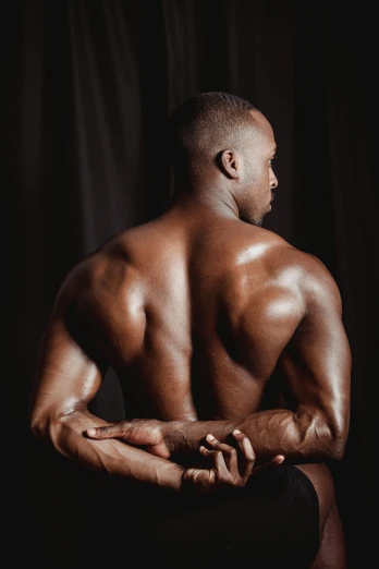a man sitting on a stool with his back to the camera, by Terrell James, athletic body build, instagram photo, oiled skin, two men hugging