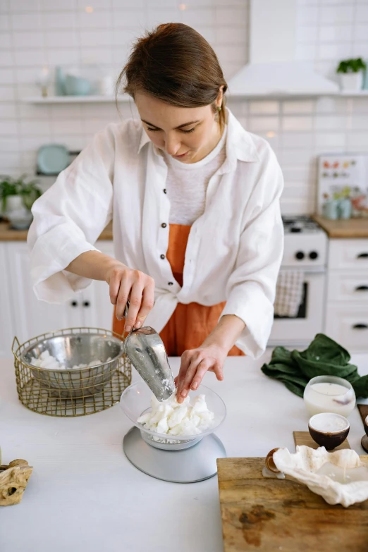a woman is preparing food in a kitchen, by Elizabeth Durack, trending on pexels, whipped cream, mozzarella, product introduction photo