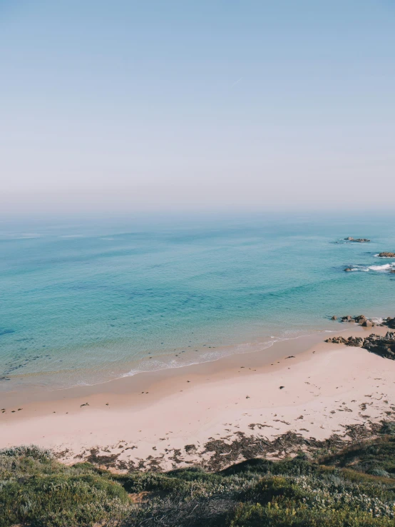 a view of a beach from the top of a hill, calmly conversing 8k, australian beach, summer vibes, high quality image”