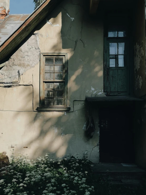 a building with a bunch of flowers in front of it, a picture, inspired by Elsa Bleda, pexels contest winner, abandoned cottage, light and shadow, light - brown wall, low quality photo