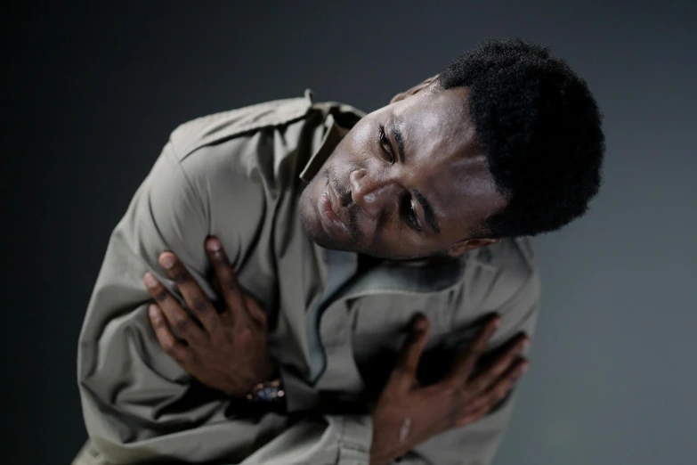 a man with his hands on his chest, an album cover, pexels, black man, solo male weary soldier, in pain, actors