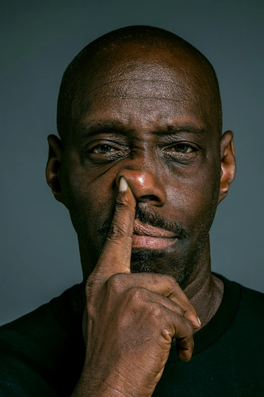 a man with a finger on his lips, by David Begbie, pexels contest winner, hyperrealism, lance reddick, tony hawk crying, black spot over left eye, headshot profile picture