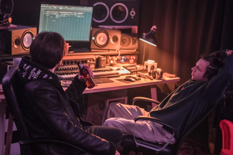 a man sitting in a chair in front of a computer, an album cover, by Jacob Toorenvliet, unsplash, two buddies sitting in a room, studio lights, sitting at a control center, production i g