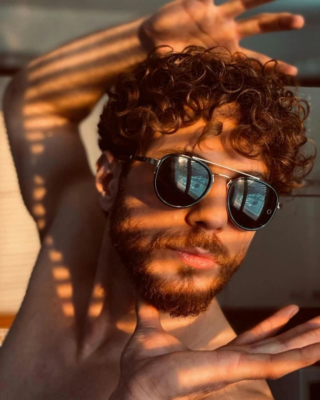 a close up of a person wearing sunglasses, by Adam Dario Keel, bisexual lighting, curly middle part haircut, very accurate photo, instagram post