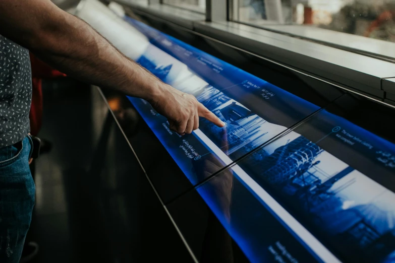 a close up of a person pointing at a display, by Emma Andijewska, trending on unsplash, glass floor, softly glowing control panels, historic moment, hyper realistic