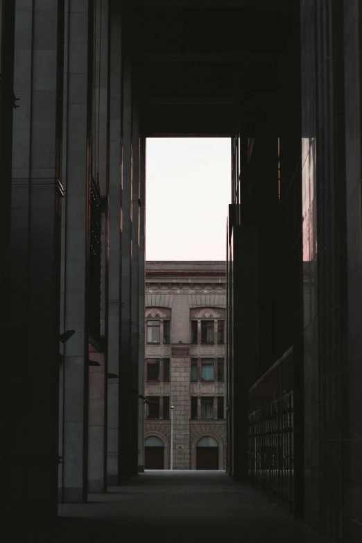 a dark hallway leading to a tall building, a picture, pexels contest winner, seen from a distance, layered composition, arches, city morning