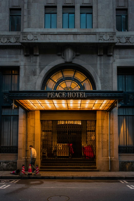 a couple of people walking in front of a hotel, peace, dramatic entry, beautifully lit, world peace