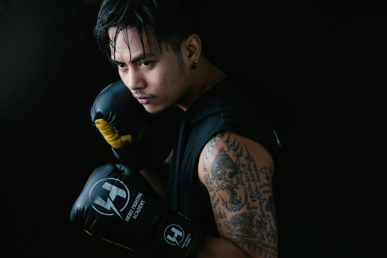 a close up of a person wearing boxing gloves, a tattoo, pexels contest winner, hurufiyya, masculine pose, avatar image, manuka, asian male