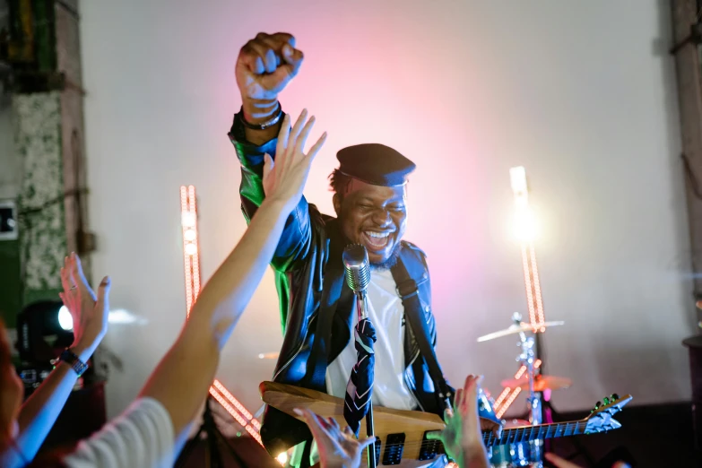 a man standing on top of a stage holding a guitar, pexels, george clinton, everyone having fun, dj at a party, unblur