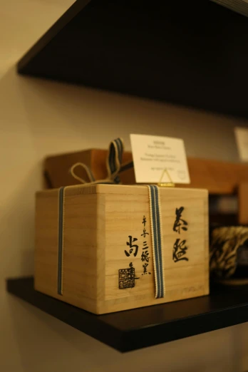 a wooden box sitting on top of a shelf, by Sengai, smelling good, ribbon, 王琛, close medium shot