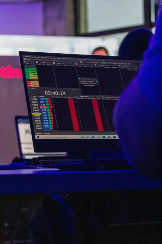 a person sitting in front of a laptop computer, an album cover, by Daarken, trending on reddit, displaying stock charts, giant red led screens, fanatec peripherals, close up to the screen