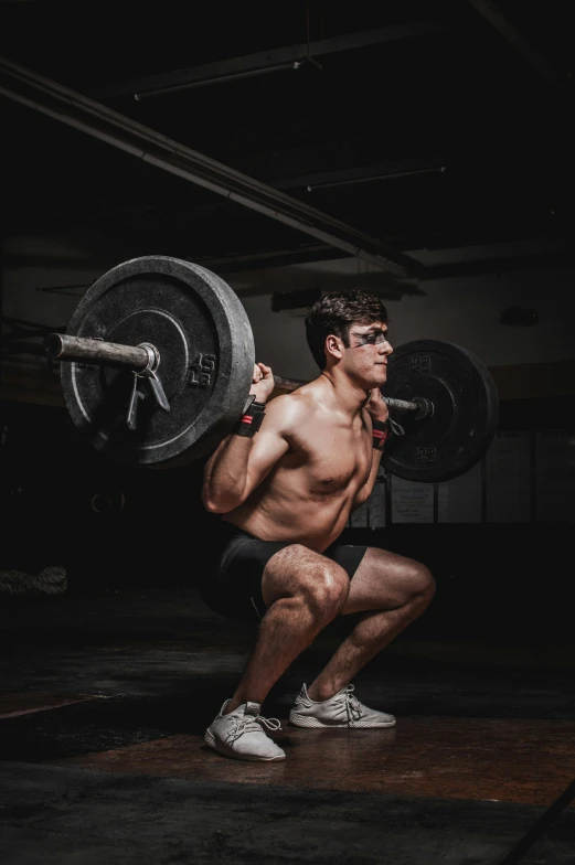 a man squatting with a barbell in a gym, a colorized photo, by Adam Marczyński, pexels contest winner, wearing a tank top and shorts, athletic crossfit build, gif, ox