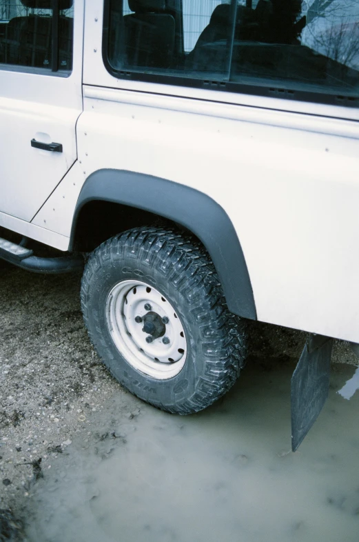 a white land rover parked on the side of a road, by Daniel Taylor, skin detail, 1990s photograph, metal tail, soft rubber