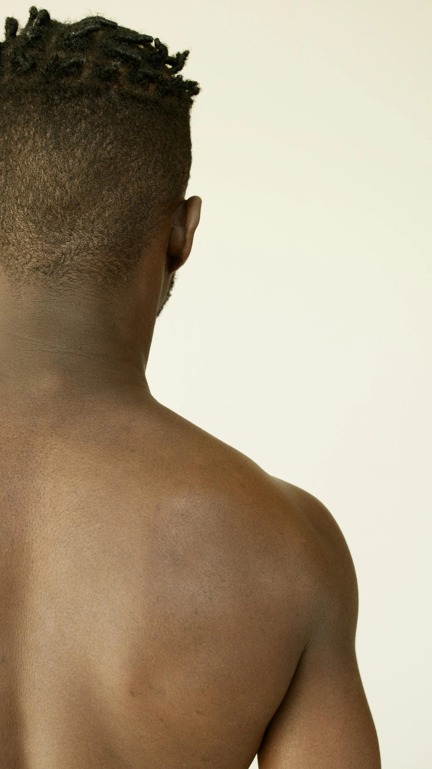 a man with his back turned to the camera, trending on pexels, skin tones, panel of black, of a muscular, chest