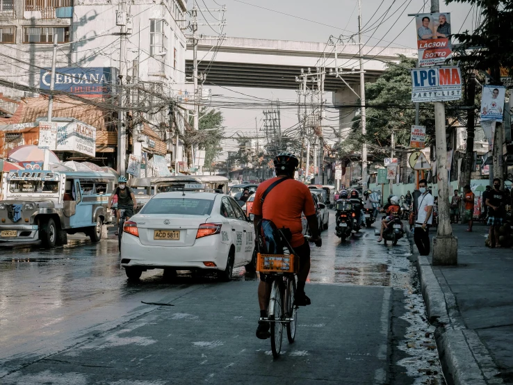 a man riding a bike down a city street, by Marshall Arisman, pexels contest winner, philippines, square, subtitles, 🚿🗝📝