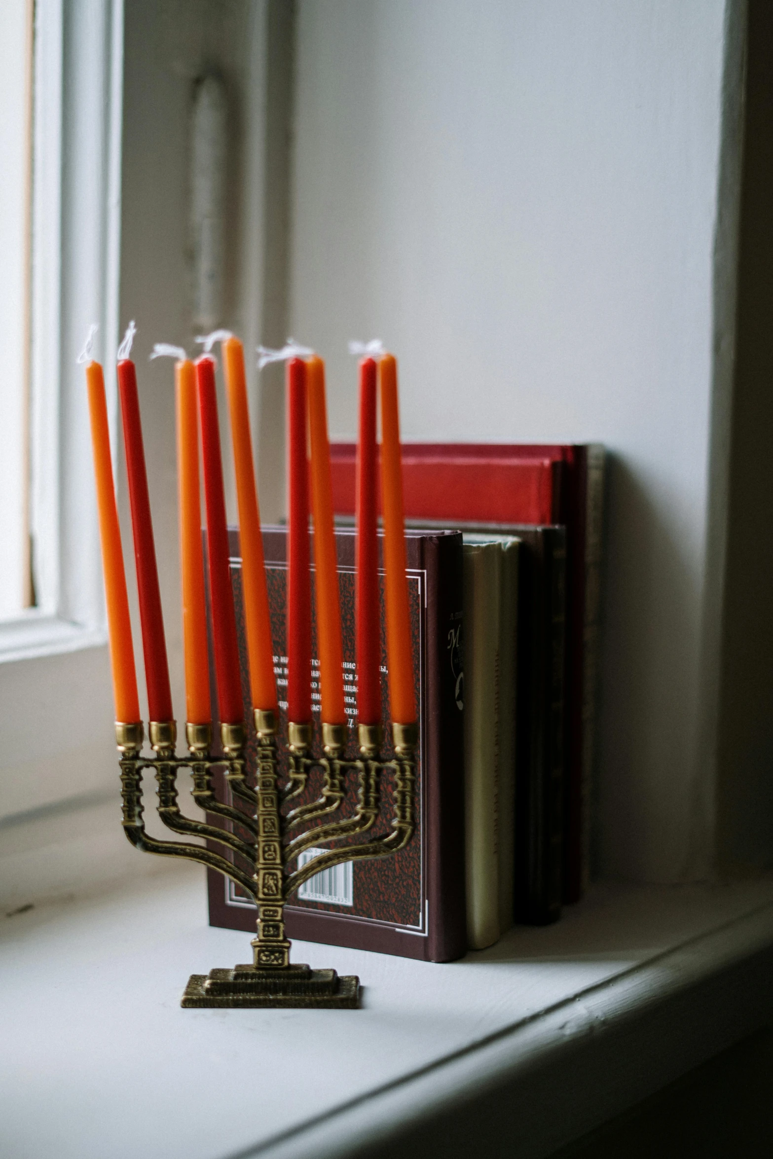 a group of candles sitting on top of a window sill, by Emanuel Witz, trending on unsplash, baroque, hebrew, orange lamp, ornate with gold trimmings, sleek spines