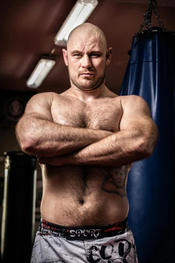 a man standing in front of a punching bag, a portrait, inspired by Brian 'Chippy' Dugan, bare hairy chest, voluptuous male, absolutely outstanding image, conor walton