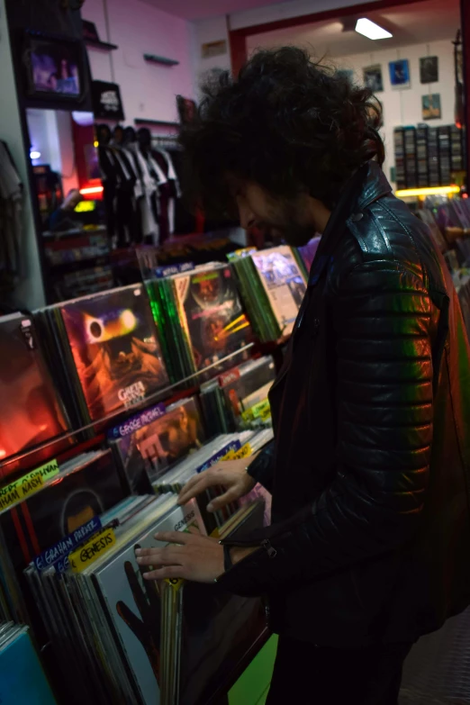 a man looking at records in a record store, an album cover, inspired by Nan Goldin, reddit, underground comix, wearing cyberpunk leather jacket, retrowave ((synthwave)), plays music, zack de la rocha