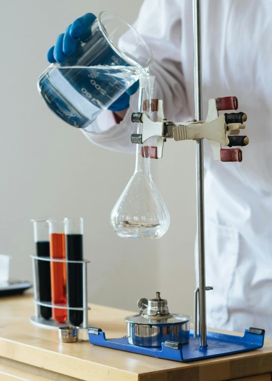 a man in a lab coat is pouring something into a flask, by Julia Pishtar, unsplash, analytical art, panels, 15081959 21121991 01012000 4k, high school, vertical orientation