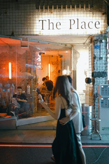 a woman walking down the street in front of a store, by Pia Fries, pexels contest winner, process art, cafe interior, けもの, fire stainglass, lit. 'the cube'
