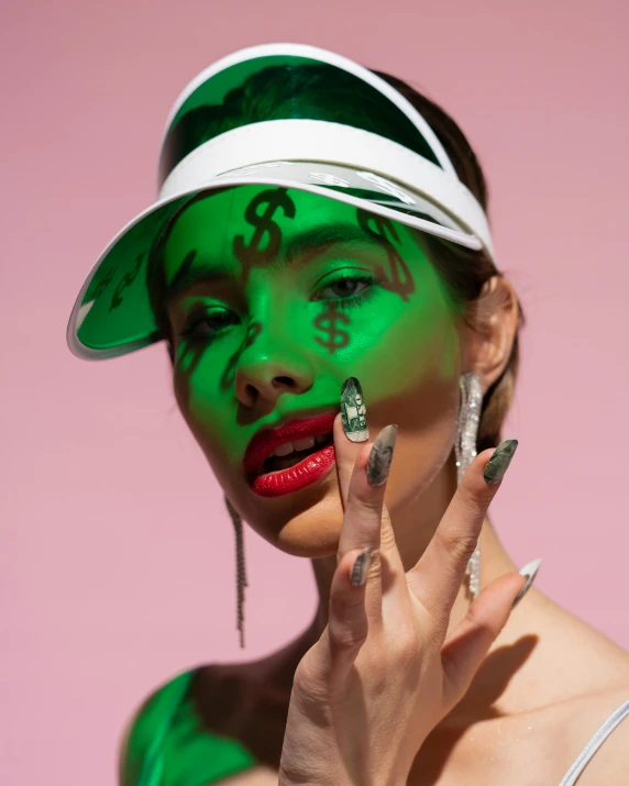 a woman with green paint on her face, an album cover, trending on pexels, fancy flashy hat, dollar sign, non binary model, bella poarch