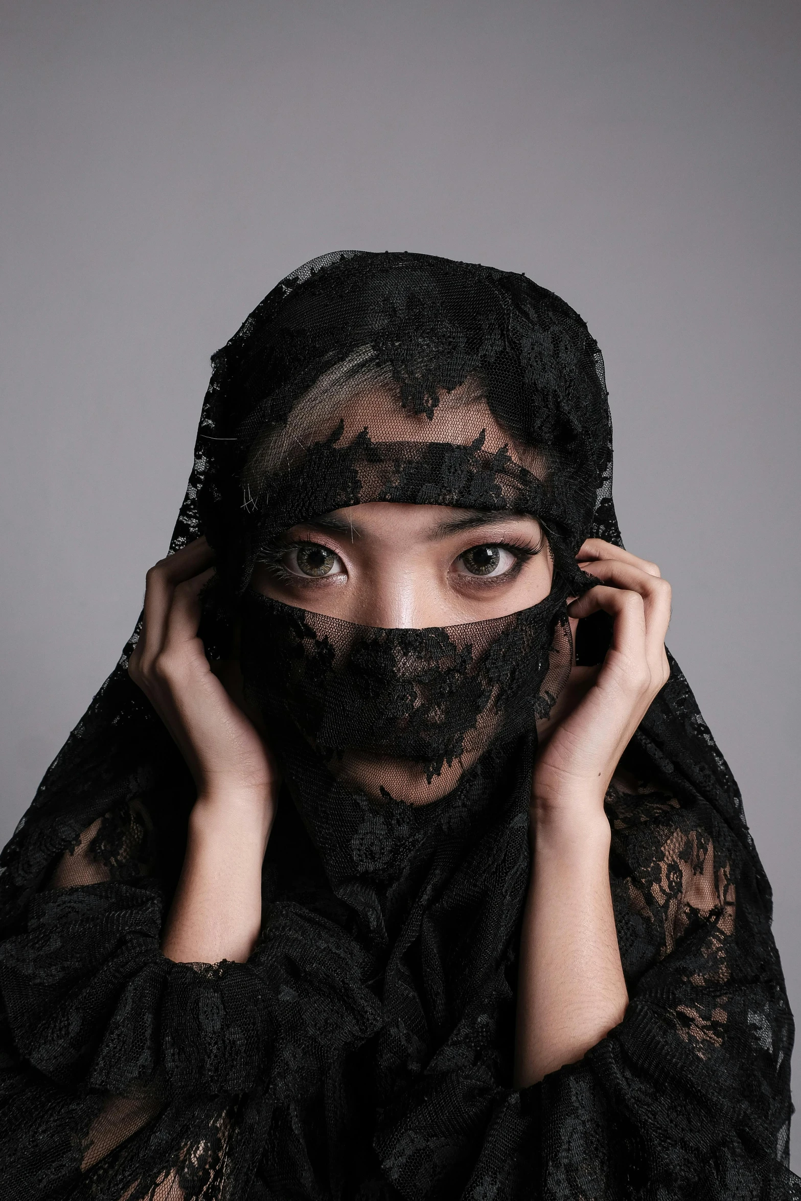 a woman in a black veil covering her face, an album cover, inspired by Yu Zhiding, trending on pexels, young cute wan asian face, lace, wearing demobaza fashion, fabric