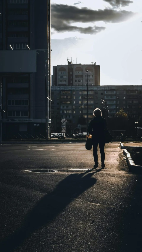 a person walking down a street holding a skateboard, by Tobias Stimmer, unsplash contest winner, happening, back light contrast, street of moscow, standing in a parking lot, 15081959 21121991 01012000 4k