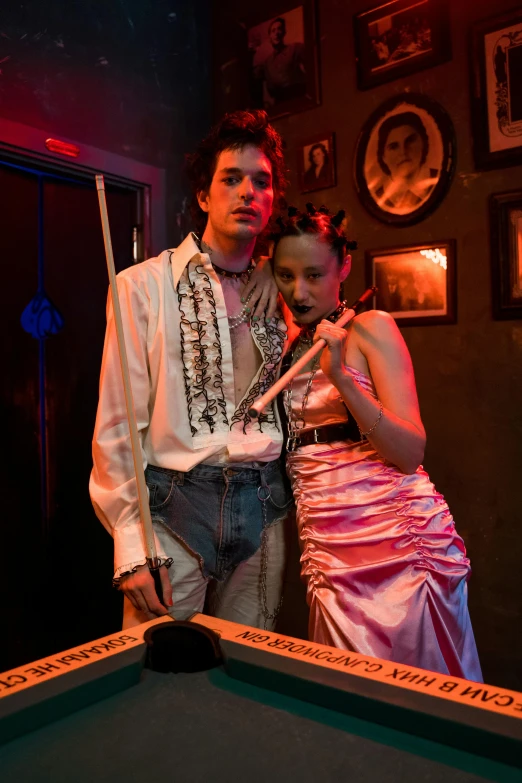 a man and a woman standing next to a pool table, inspired by Nan Goldin, renaissance, dressed in crustpunk clothing, the little circus of horrors, premiere, ( ( theatrical ) )