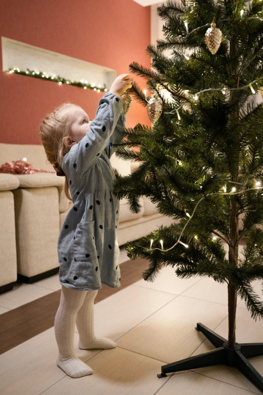 a little girl standing next to a christmas tree, profile image, thumbnail, small, decoration