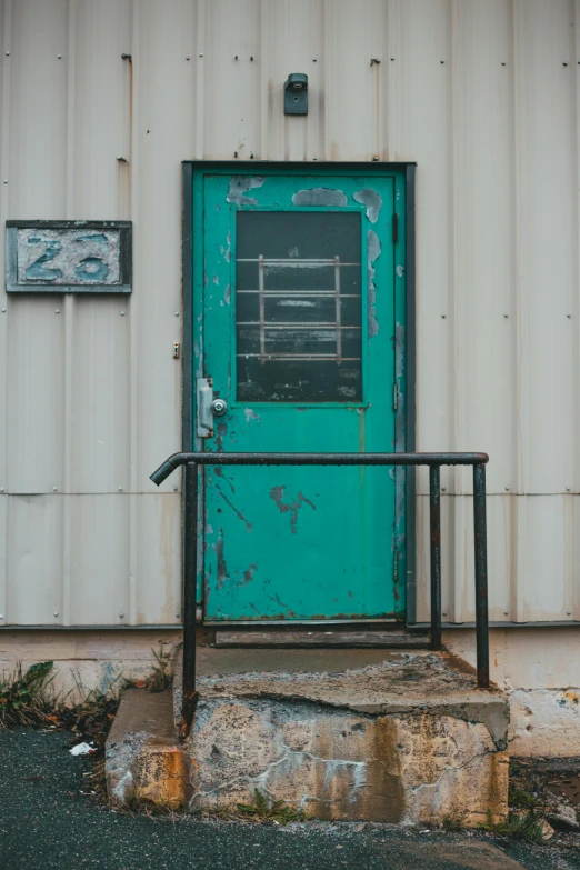 a green door sitting on the side of a building, inspired by Elsa Bleda, unsplash, trailer park, abandoned laboratory, high quality photo, square