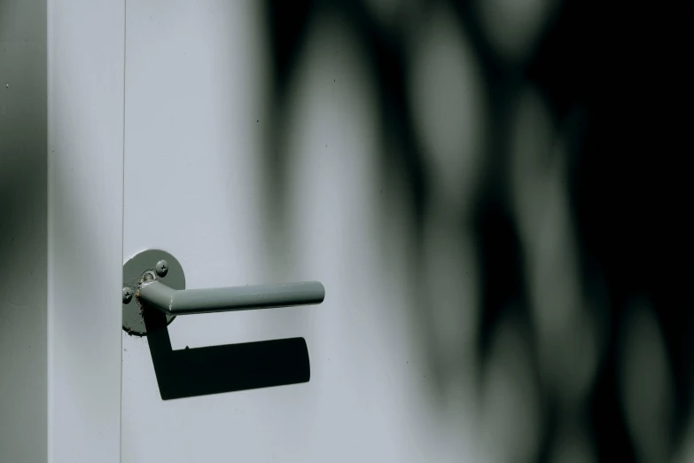 a black and white photo of a door handle, an abstract sculpture, unsplash, bauhaus, security camera footage, a green, ignant, taken in the late 2000s