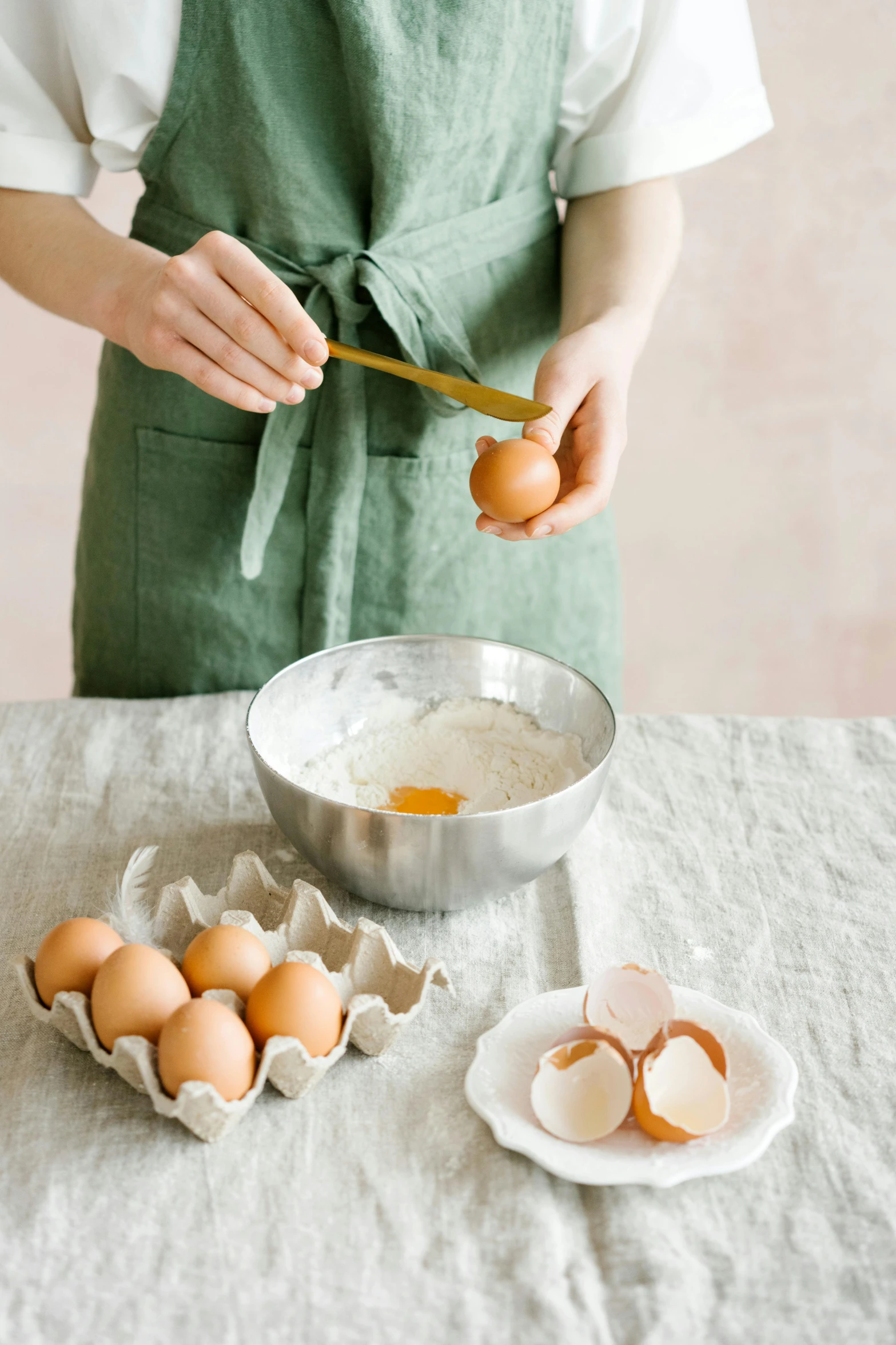 a woman in an apron scooping eggs into a bowl, a still life, inspired by Elsa Beskow, trending on unsplash, eggshell color, high quality product photo, made of glazed, multi-part
