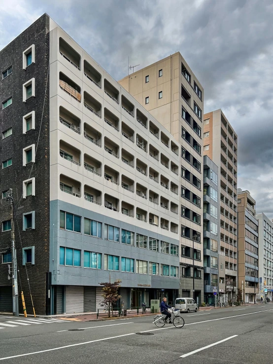 a tall building sitting on the side of a road, shin hanga, architectural photo, color image, grey, 5 th floor