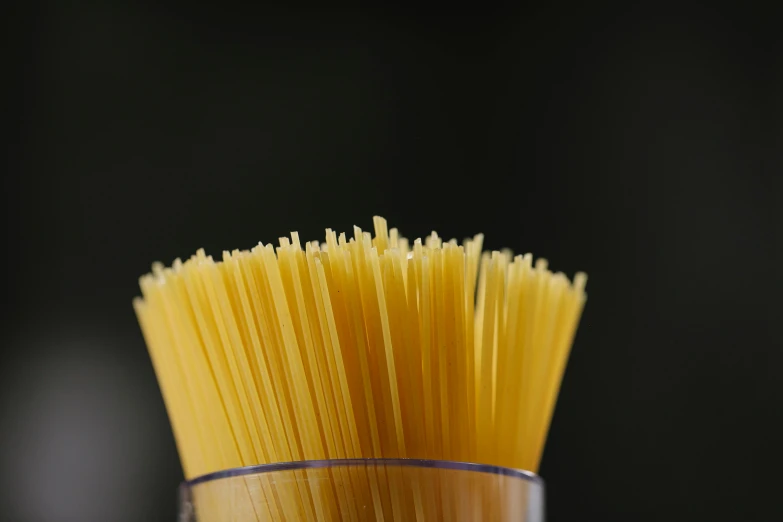 a glass filled with spaghetti noodles on top of a table, by Adam Marczyński, pexels, close up. macro. hyper realistic, gif, stacked image, spatula