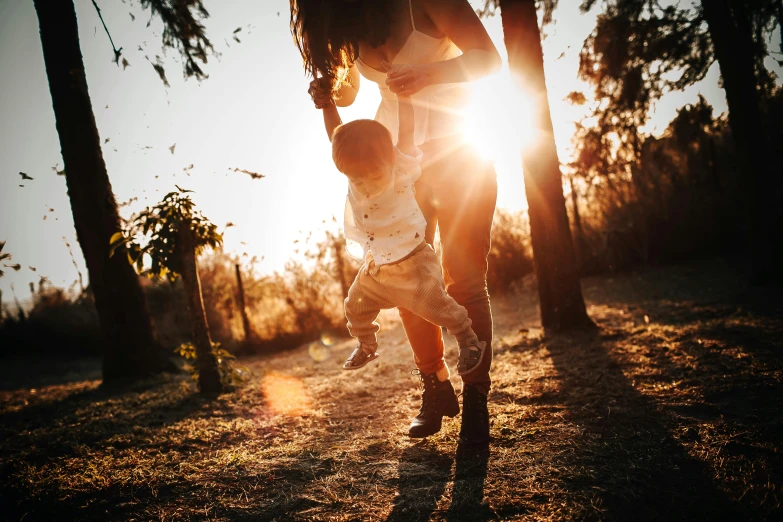 a woman holding a small child in her arms, pexels contest winner, beautiful raking sunlight, running towards camera, thumbnail, son