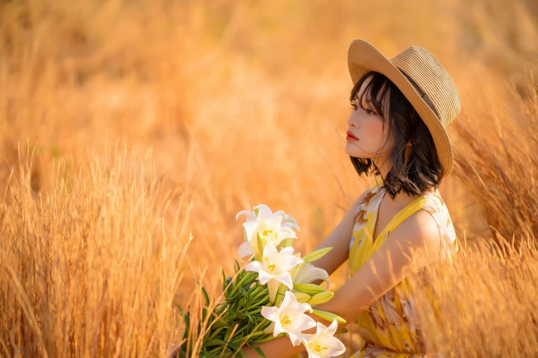 a woman sitting in a field holding a bunch of flowers, inspired by Tan Ting-pho, pexels contest winner, lilies, straw hat, profile image, korean girl