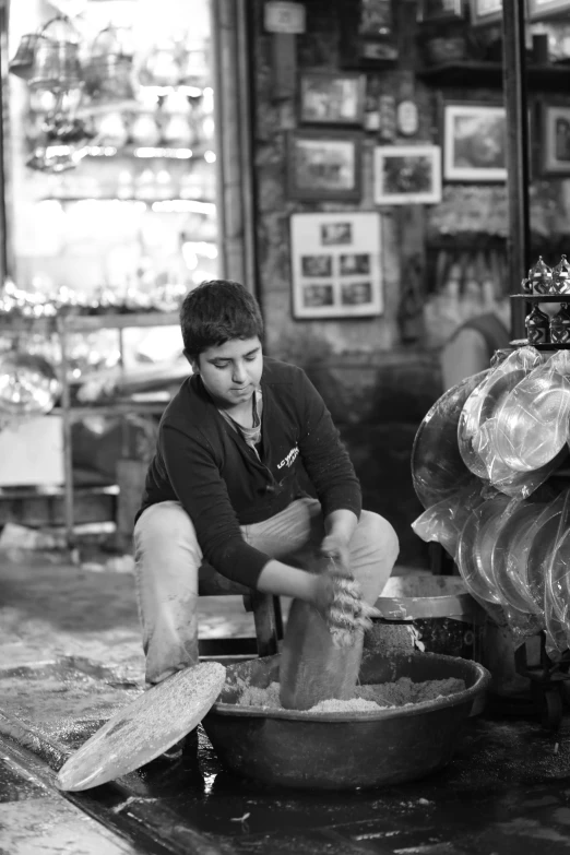 a black and white photo of a man making pottery, a picture, inspired by Larry Fink, cute boy, damascus, inside an old magical sweet shop, (beautiful) girl