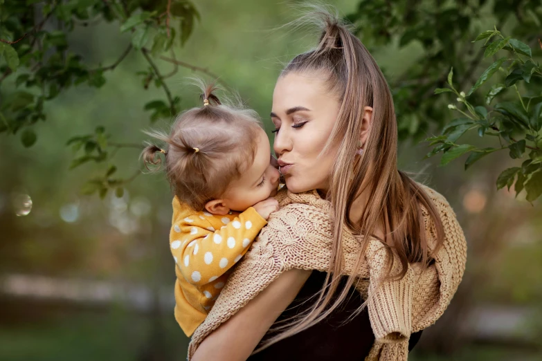 a woman holding a baby in her arms, a picture, by Julia Pishtar, shutterstock, color photograph portrait 4k, square, autum, attractive girl