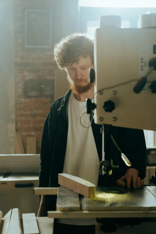 a man that is standing in front of a table, a picture, holding wood saw, portrait featured on unsplash, future coder man looking on, australian