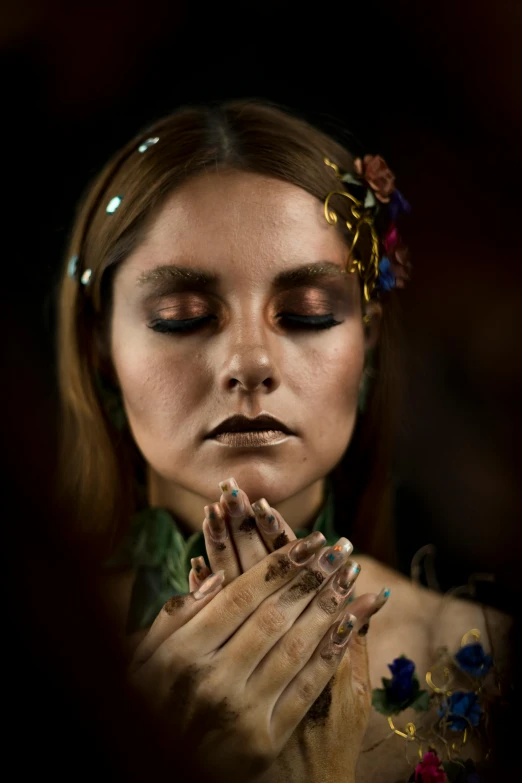 a woman with a flower in her hair, inspired by Elsa Bleda, renaissance, prayer hands, wearing war paint, with professional makeup, a druid