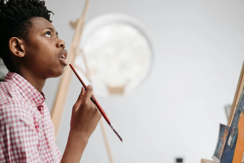 a woman holding a paintbrush in front of a painting, a child's drawing, by Lee Loughridge, pexels contest winner, looking off to the side, pencil drawing of mkbhd, looking upward, studious