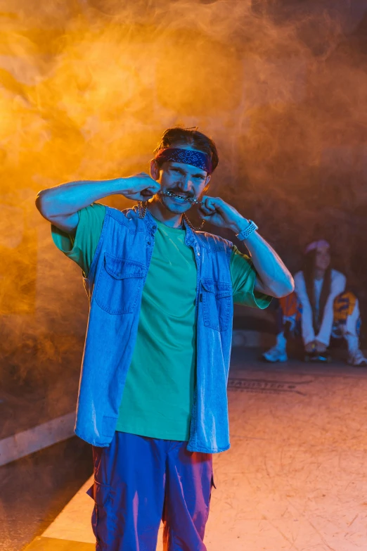 a man standing on a sidewalk talking on a cell phone, an album cover, trending on pexels, graffiti, in blue and yellow clothes, standing in a dimly lit room, fancy dress, mrbeast