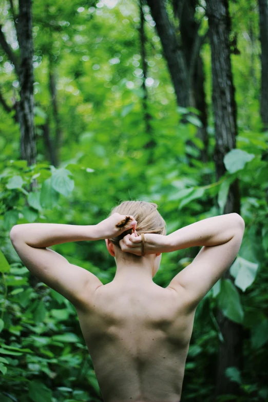 a man standing in the woods with his back to the camera, inspired by Ren Hang, renaissance, hands in her hair, pale hair, lush greenery, ignant