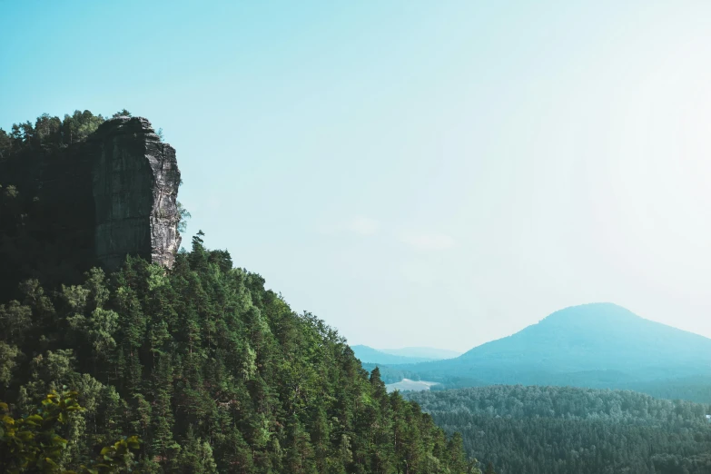 a group of people standing on top of a mountain, trees and cliffs, jovana rikalo, towering high up over your view, seen from a distance