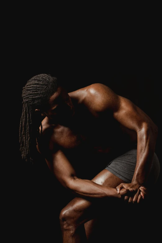 a man sitting on a skateboard in the dark, an album cover, by Terrell James, renaissance, muscular men entwined together, profile image, hugging her knees, body builder